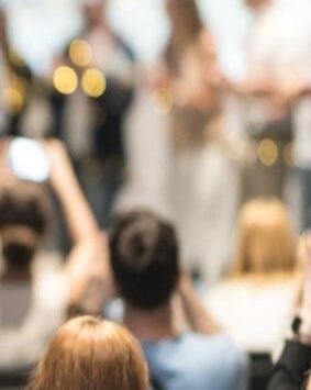 A blurred image of people at a social event, capturing the essence of award giving ceremony